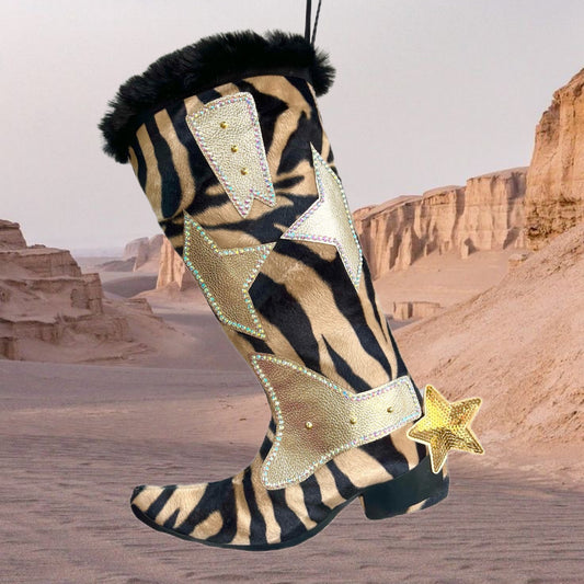 Zebra-patterned boot with gold accents and star details against a desert landscape